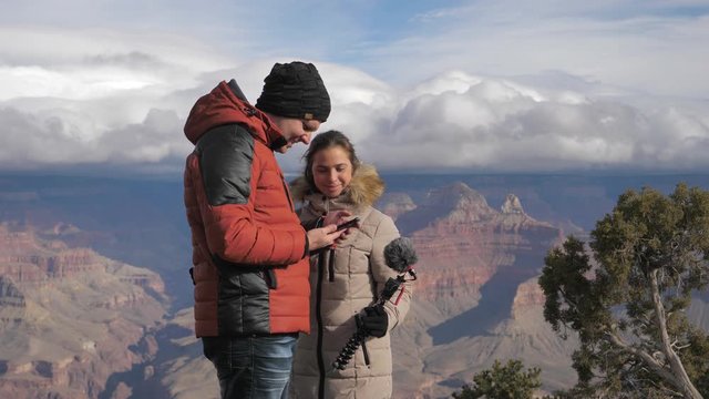 Young couple bloggers vloggers take selfie photo videos at Grand Canyon 