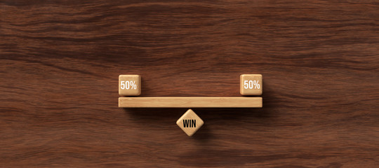 wooden blocks formed as a seesaw with the number 50% and the word WIN on wooden background,...