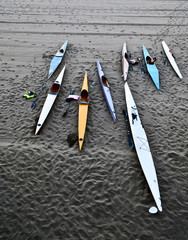 Many colorful kayaks on a black volcanic beach, life vests and paddles, ready for an evening ride...