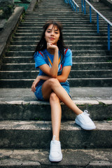 Obraz premium Girl in blue clothes cross-legged sitting on a staircase