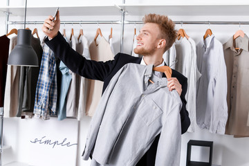 Stylish young man taking selfie in dressing room