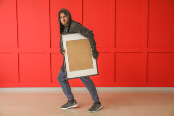 Thief stealing picture from art gallery