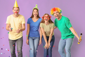 People in funny disguise on color background. April fools' day celebration