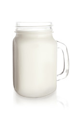 Mason jar of tasty milk on white background