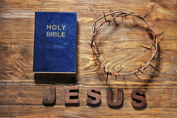 Wreath of thornes, Bible and word JESUS on wooden background