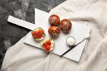 Fresh buns with tasty cream cheese and vegetables on table