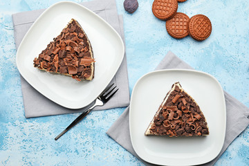 Plates with pieces of tasty chocolate cheesecake on table