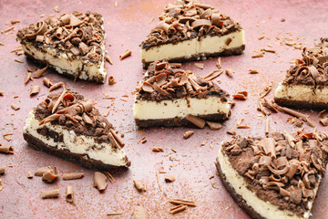 Pieces of tasty chocolate cheesecake on color background