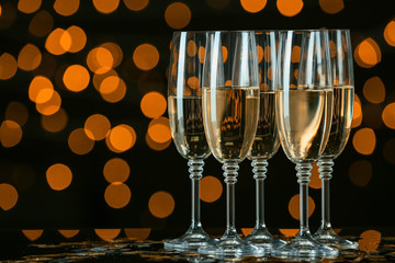 Glasses of tasty champagne on dark background
