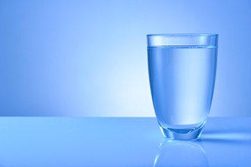 Glass of fresh water on color background