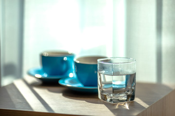 Blurred background view of a mug or coffee cup, a cup of water or a drink on the table, for customer service in a room or restaurant