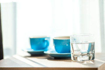 Blurred background view of a mug or coffee cup, a cup of water or a drink on the table, for customer service in a room or restaurant