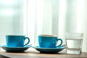 Blurred background view of a mug or coffee cup, a cup of water or a drink on the table, for customer service in a room or restaurant