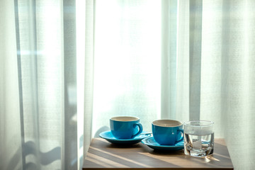 Fototapeta na wymiar Blurred background view of a mug or coffee cup, a cup of water or a drink on the table, for customer service in a room or restaurant