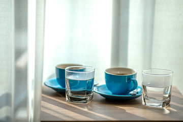 Blurred background view of a mug or coffee cup, a cup of water or a drink on the table, for customer service in a room or restaurant