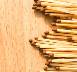 many wooden matches lie on a wooden background. flammable matches on a wooden table.
