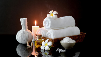 Close up view of spa treatment accessories with white towel, candle and aroma oil