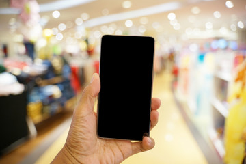 Holding phone with blurry background at mall