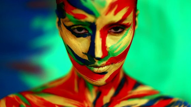 Color face art and body paint on woman for inspiration. Abstract portrait of the bright beautiful girl with colorful make-up and bodyart.