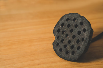 Black dry lotus seed on wooden table background