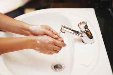 women washing hands with sanitizer soap and water after using a public restroom.Hygiene concept. prevent the spread of germs and bacteria and avoid infections