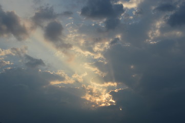 Naklejka na ściany i meble The light from the sun shining through the clouds