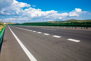 Fototapeta premium Empty highway, blue sky and white clouds landscape