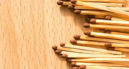 many wooden matches lie on a wooden background. flammable matches on a wooden table.