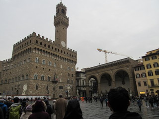 Obraz premium The Palazzo Vecchio which is the town hall of Florence, Italy with Piazza della Signoria crowded with tourists
