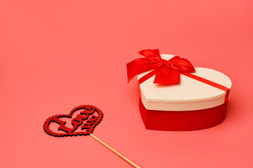 Gift box with a red ribbon and  wooden sign with the inscription: I love you  on a pink background for Valentine's day,  women's day, Birthday