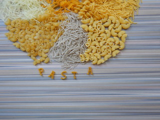 different pasta backround on a striped table and the inscription pasta