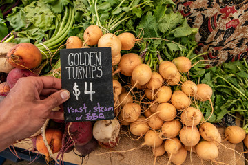 Hand written blackboard sign with the price of golden turnips at the local farmer's market. Real,...