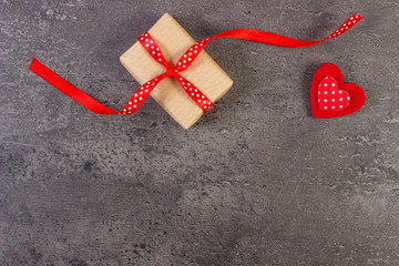 Wrapped gift and red heart for Valentines Day. Copy space for text