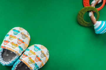 soft slippers slippers made of eco-friendly natural fabrics with teething toy on a smooth green...