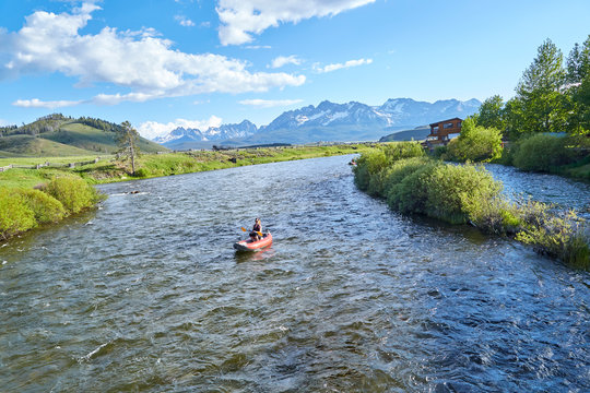 River rafting down the middle of a mountain stream on a beautiful summer day in the Sawtooth mountains