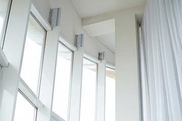 high white plastic panoramic windows and white curtains in a bright apartment