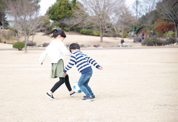 公園でサッカーをする子供