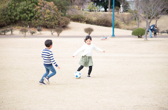 公園でサッカーをする子供