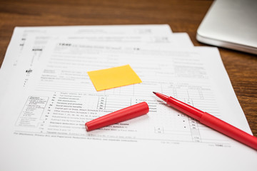 The pen and sticky note are on the tax form 1040 U.S. Individual Income Tax Return. The time to pay taxes. Business concept.
