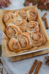 Cinnamon rolls with sugar frosting. With cinnamon sticks and spices, wooden background