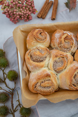 Cinnamon rolls with sugar frosting. With cinnamon sticks and spices, wooden background