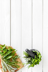 Make seasoning and condiments. Herbs in mortar on white wooden background top-down copy space