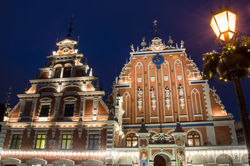 Fototapeta na wymiar View of famous House of the Black Heads illuminated at night and lantern with Christmas decoration, Riga, Latvia