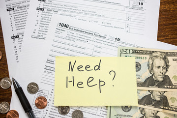 Need help text with 1040 USA tax form, cash 20 dollar bills, coins and pen on desk