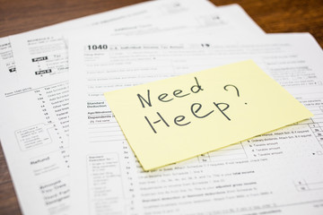 Obraz premium Need help text on sticker with blank 1040 tax return U.S. IRS form. Tax season.