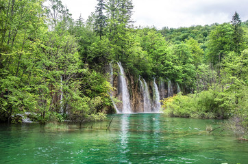 View of waterfalls with turquoise water and green trees in Plitvice Lakes National Park in summer, Croatia, Europe. Travel destinations background.