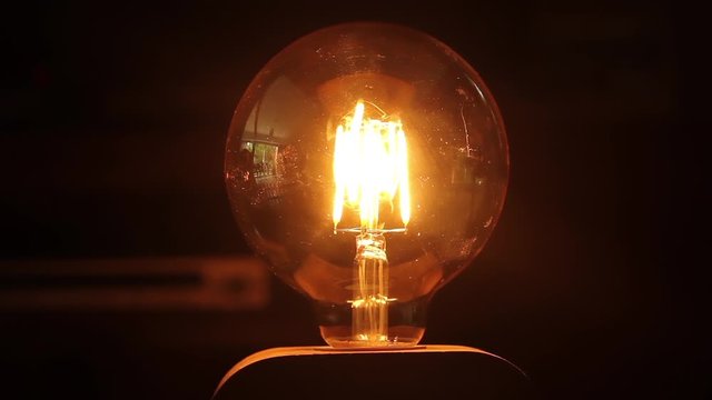 Round Light Bulb with Wood Base in a Loft Style. Close-Up