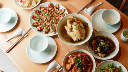 Delicious Chinese traditional food arranged on wooden table for dinner.