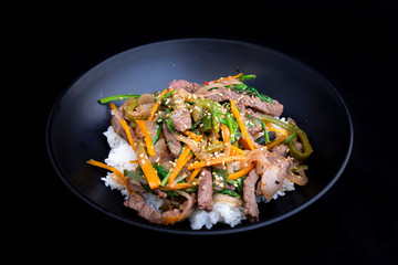 stir fry beef and vegetables with rice in the bowl