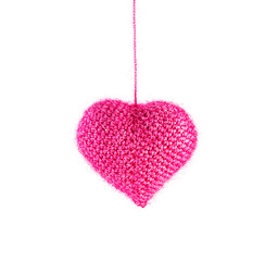 Beautiful knitted pink heart, christmas toy hanging isolated on white
